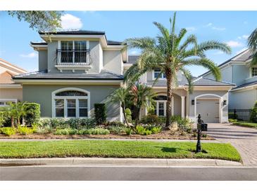 Charming two-story home featuring a well-manicured lawn, tropical landscaping, and a gray stucco exterior at 16629 Sedona De Avila, Tampa, FL 33613