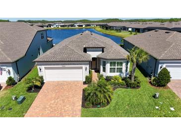 Beautifully landscaped single-Gathering home with a two-car garage and water view at 19442 Sea Glass Cir, Land O Lakes, FL 34638