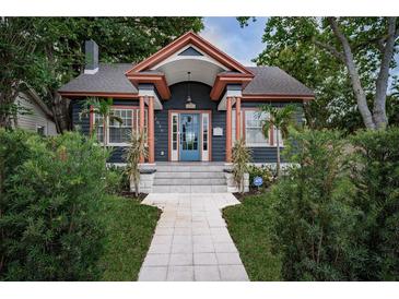 Charming home featuring a blue door, copper accents, and a well-manicured walkway and landscaping at 2536 Burlington N Ave, St Petersburg, FL 33713