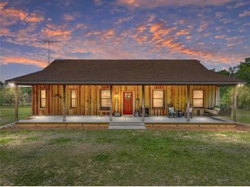Charming single-story home with a full-length porch and inviting red front door at 35657 Ashley Ln, Dade City, FL 33523