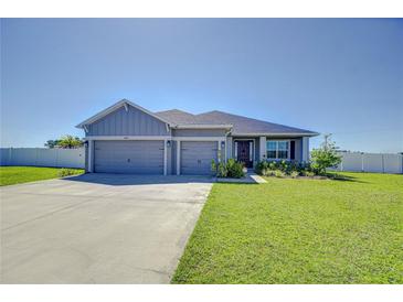 Charming single-story home with a two-car garage, well-maintained lawn, and welcoming front entrance at 4444 Devinshire Fields Loop, Plant City, FL 33567