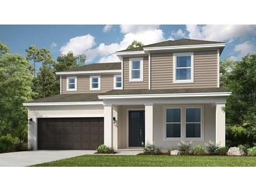 Charming two-story home featuring a covered porch, attached two-car garage, and manicured lawn at 813 Steel Dr, Apollo Beach, FL 33572