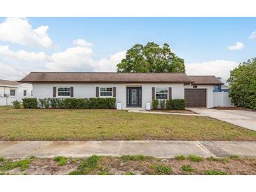 Charming single-story home with a well-manicured lawn, clean design, and a two-car garage at 8721 Bay Crest Ln, Tampa, FL 33615