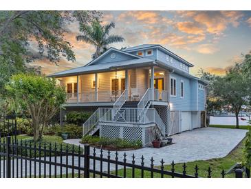 Beautiful two-story home with a charming porch and a well-manicured lawn, perfect for waterfront living at 2314 N Riverside Dr, Tampa, FL 33602