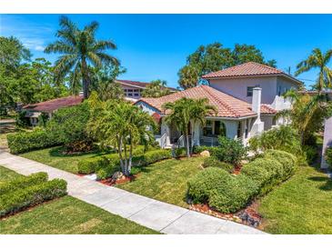 Charming home showcasing a tile roof, lush landscaping, and a welcoming front porch at 2421 Brevard Ne Rd, St Petersburg, FL 33704