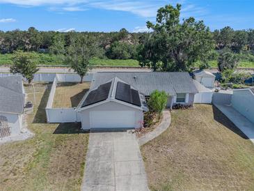 Aerial view of a single-story home with solar panels, fenced yard, and concrete driveway at 512 Red Mangrove Ln, Apollo Beach, FL 33572