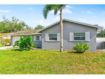 Charming single-story home featuring a well-maintained lawn and a gray exterior with white trim at 5519 Homewood Dr, Sarasota, FL 34232