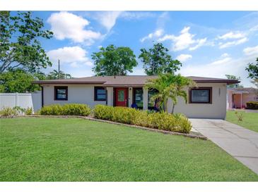 Charming single-story home featuring a well-maintained lawn, mature trees, and inviting curb appeal on a sunny day at 5591 15Th N Ave, St Petersburg, FL 33710
