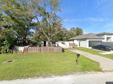 Charming single-Gathering home with a well-maintained lawn and a private driveway and an interesting older structure behind it at 6065 105Th Ave, Pinellas Park, FL 33782