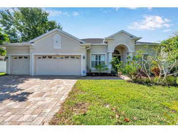 Charming single-story home with a three-car garage, paver driveway, and manicured landscaping at 6130 Japonica Ct, New Port Richey, FL 34655