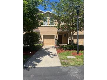 Two-story townhouse with a well-manicured lawn and a light brown colored facade at 778 Spring Flowers Trl, Brandon, FL 33511