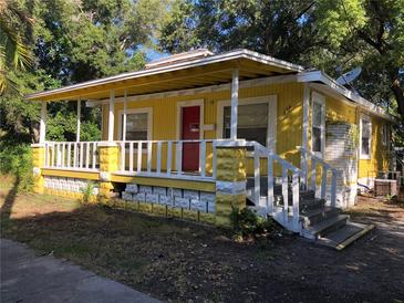 Charming single-story home with a cozy front porch, complemented by a bright yellow facade and a red door at 1045 13Th S Ave, St Petersburg, FL 33705