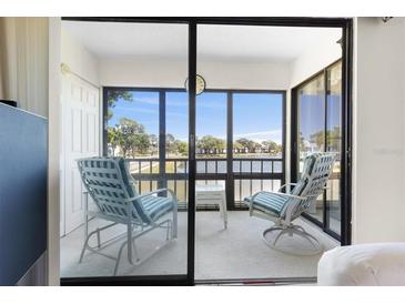 Enclosed patio with outdoor seating, overlooking a tranquil lake with serene water view at 108 Lakeview Ct # 108, Oldsmar, FL 34677