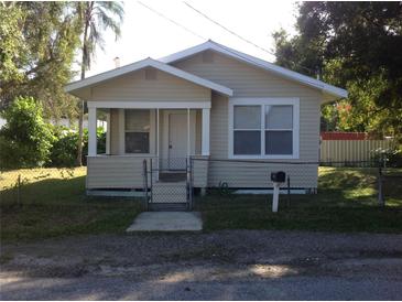 Charming single-story home with a small porch, fenced yard, and well-maintained lawn on a sunny day at 2217 N 64Th St, Tampa, FL 33619