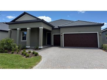 Beautiful exterior of a single-story home featuring a tile roof and a two-car garage at 31556 Cardinal Yard Dr, San Antonio, FL 33576