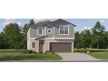 Charming two-story home with gray siding, an attached garage, and well-manicured front lawn at 6508 Top Hill Dr, New Port Richey, FL 34655