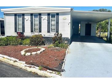Charming single-story home with a covered carport and attractive landscaping at 9790 66Th N St # 80, Pinellas Park, FL 33782