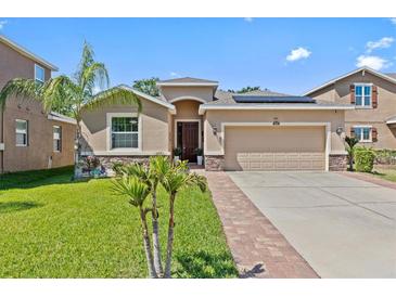 Charming single-story home with well-manicured lawn, stone accents, and a two-car garage at 10514 Scenic Hollow Dr, Riverview, FL 33578