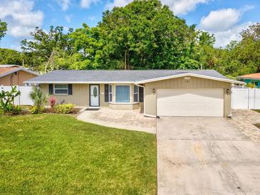Charming single-story home featuring a well-maintained lawn, attached garage, and inviting front entrance at 1390 S Hillcrest Ave, Clearwater, FL 33756