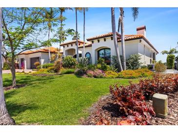 Beautiful home featuring a Spanish tile roof, lush landscaping, and a well-manicured lawn at 2012 Carolina Ne Cir, St Petersburg, FL 33703