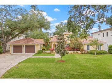 Charming single-Gathering home featuring a well-manicured lawn and an attached two-car garage at 3215 W Fair Oaks Ave, Tampa, FL 33611