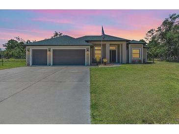 Charming single-story home featuring a spacious three-car garage and well-manicured lawn at 4323 Baynes Rd, North Port, FL 34288