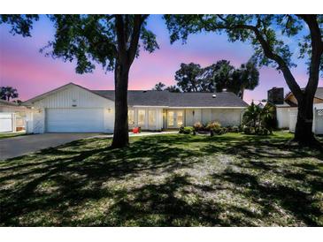 Charming home with a manicured lawn, mature trees and lovely landscaping at 4368 Marine Pkwy, New Port Richey, FL 34652