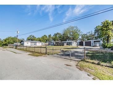 This property features multiple buildings, a gated yard, and mature trees at 9236 Suncoast Terrace, Hudson, FL 34667