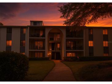 Beautiful multi-story condo building with balconies and landscaped lawn during a sunset at 1309 Pine Ridge E Cir # D3, Tarpon Springs, FL 34688
