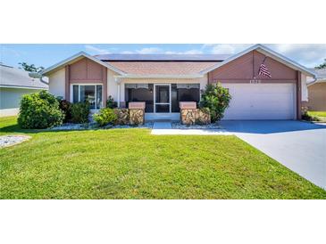 Charming single-story home with a well-maintained lawn, stone accents, and an attached garage at 1575 Wicklow Dr, Palm Harbor, FL 34684