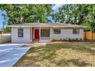 Charming single-story home with a well-manicured lawn, a bright red front door, and a welcoming entrance at 2106 W Saint Isabel St, Tampa, FL 33607