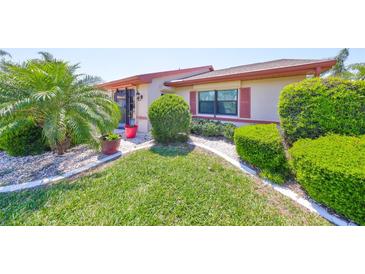 Charming single-story home features manicured landscaping, decorative stone, and lush green grass at 2509 Locksley St # 237, Sun City Center, FL 33573