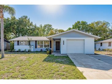 Charming single-story home with a well-maintained lawn, a bright, white exterior and a one car garage at 10137 Oleander Dr, Port Richey, FL 34668