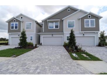 Two-story townhome featuring a brick paver driveway and attached one car garage at 10708 Oak Bend Dr, Parrish, FL 34219