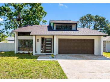 Charming single-Gathering home with modern door, attached garage and well manicured front lawn at 15307 Summerwind Dr, Tampa, FL 33624