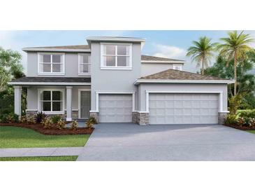 Modern two-story home boasts a three-car garage, manicured lawn, and contemporary architectural details at 2250 Rikkola Ln, Wesley Chapel, FL 33543