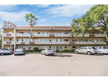 Multi-level condo complex with ample parking, mature trees, and well-maintained facade under a sunny sky at 2310 Denmark St # 30, Clearwater, FL 33763