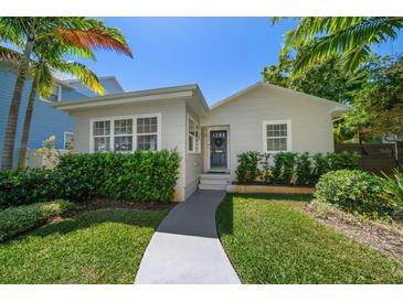 Charming home showcasing a beautiful yard, lush bushes, and a welcoming blue front door with a wreath at 246 20Th Ne Ave, St Petersburg, FL 33704