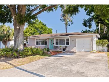 Charming one-story home featuring a tidy front yard, a one car garage, and mature landscaping at 725 85Th N Ave, St Petersburg, FL 33702