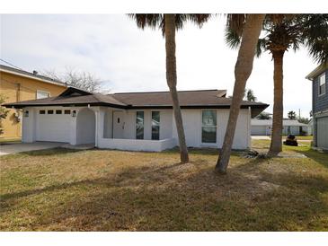 Charming single-story home featuring a fresh white paint job and a two-car garage at 7534 Mako Dr, Hudson, FL 34667