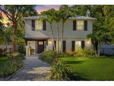 Charming two-story home featuring a manicured front yard, paver walkway, and inviting entrance at 8020 Sharon Dr, Tampa, FL 33617