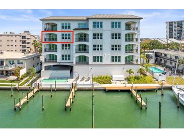 A beautiful view of the building exterior, including the pool, dock, and waterway at 211 Dolphin Pt # 403, Clearwater Beach, FL 33767