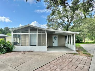 Charming home featuring a screened-in porch and covered carport, perfect for enjoying the outdoors at 34141 Tree Lake Dr, Wesley Chapel, FL 33543