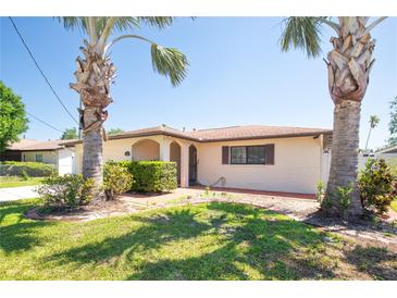 Charming single-story home with a well-manicured lawn and beautiful mature palm trees in the front yard at 5921 Denver Ne St, St Petersburg, FL 33703