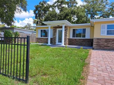 Charming home featuring a well-kept lawn and stone accents under the windows, and a gated fence at 844 67Th S St, South Pasadena, FL 33707