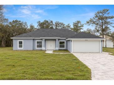 Charming single-story home with a paved driveway, attached garage, and well-manicured lawn at 10262 Maybird Ave, Weeki Wachee, FL 34613