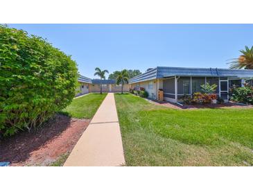 Community courtyard featuring meticulously maintained green spaces, lush landscaping and well-lit walkways at 1802 Bedford Ter # 187, Sun City Center, FL 33573