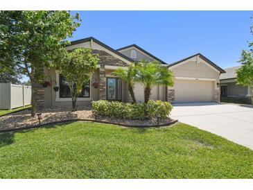 Charming single-story home with stone accents, manicured lawn, and mature landscaping at 18796 Obregan Dr, Spring Hill, FL 34610