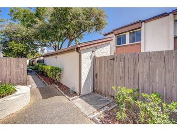Charming walkway leading to a well-maintained home with mature landscaping and wooden fence at 1881 N Hercules Ave # 1303, Clearwater, FL 33765