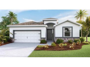 Charming single-story home with a two-car garage, stone accents, and well-maintained landscaping at 3320 Amber Waves Dr, Plant City, FL 33565